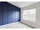 Bedroom featuring a blue accent wall and a large window at 11488 E 25Th Dr, Aurora, CO 80010