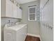 Bright laundry room with a washer, dryer, upper cabinets and hanging rack on the wall at 6738 Esmeralda Dr, Castle Rock, CO 80108