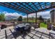 A beautiful outdoor patio with pergola, built-in seating, and a lovely backyard at 6738 Esmeralda Dr, Castle Rock, CO 80108