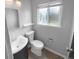 Cozy half bath with a vanity sink and a modern toilet underneath a sunny window at 13235 Rigel Dr, Lone Tree, CO 80124