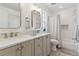 Bright bathroom featuring double sink vanity, soaking tub with shower, neutral color palette at 2840 S Bannock St, Englewood, CO 80110