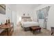 Bright bedroom with a tufted headboard, bench, and large windows providing ample natural light at 2840 S Bannock St, Englewood, CO 80110