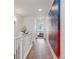 Hallway featuring hardwood floors, large modern art piece, leading to bedroom with open door at 2840 S Bannock St, Englewood, CO 80110