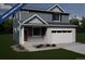 Two-story house with gray siding, white garage door, and landscaping at 3946 N Riviera Ct, Aurora, CO 80019