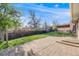 Lovely brick patio with steps up to a spacious grassy backyard with mature trees and a privacy fence at 772 Urban Ct, Lakewood, CO 80401