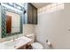 Stylish half bath with unique mirror, vanity, and tiled accents at 772 Urban Ct, Lakewood, CO 80401