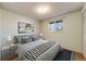Comfortable bedroom featuring a large window, soft lighting, and a stylish gray bed at 772 Urban Ct, Lakewood, CO 80401