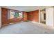 Comfortable living room with neutral carpeting, a textured accent wall, and ample natural light at 772 Urban Ct, Lakewood, CO 80401