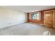 Clean living room with a large window, carpet flooring, and entryway into the house at 772 Urban Ct, Lakewood, CO 80401