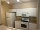 Efficient kitchen with white appliances, ample white cabinetry, and light countertops at 5255 Memphis St # 712, Denver, CO 80239