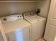 Compact laundry room with a side-by-side washer and dryer and a white door at 5255 Memphis St # 712, Denver, CO 80239