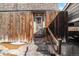 Exterior view of townhouse entrance with wooden fence and steps leading to the door at 1557 S Owens St # 59, Denver, CO 80232