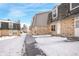 Townhouse complex with snow-covered walkways and landscaping at 1557 S Owens St # 59, Denver, CO 80232