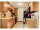 Galley kitchen with wood cabinets and appliances at 1557 S Owens St # 59, Denver, CO 80232