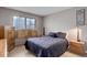 Bedroom has a gray comforter with wood style nightstands and lamps at 12430 E Pacific Cir # B, Aurora, CO 80014