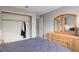 Bright bedroom featuring a light gray wall, wooden dresser, and ample closet space at 12430 E Pacific Cir # B, Aurora, CO 80014