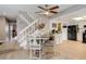 Dining area with modern chairs and a view of the stairway and kitchen with black appliances and neutral-toned cabinets at 12430 E Pacific Cir # B, Aurora, CO 80014