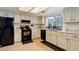 Bright kitchen featuring white cabinets, black appliances, modern countertops, and recessed lighting creating a clean look at 12430 E Pacific Cir # B, Aurora, CO 80014