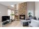 Inviting living room with a stone fireplace, modern furniture, bright windows, and neutral paint creating a warm atmosphere at 12430 E Pacific Cir # B, Aurora, CO 80014