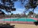 Enclosed outdoor community tennis courts surrounded by trees and shrubbery against a blue sky at 12430 E Pacific Cir # B, Aurora, CO 80014