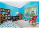 Bright bedroom with blue walls, window with patterned curtains, rocking chair, and built-in bookshelf at 1160 S Sherman St, Denver, CO 80210