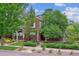 Charming two-story brick home featuring mature landscaping, a well-manicured lawn, and a welcoming front porch at 1160 S Sherman St, Denver, CO 80210