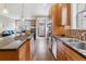Well-lit kitchen features hardwood floors, stainless appliances, stone countertops, island and easy access to living room at 1160 S Sherman St, Denver, CO 80210