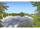 Scenic view of a serene pond reflecting the clear blue sky and surrounding greenery at 2101 Champlain Dr, Boulder, CO 80301