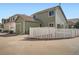 Back exterior of a green home featuring a fenced yard and a concrete driveway at 21472 E 46Th Ave, Denver, CO 80249