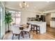 Bright eat-in kitchen featuring white cabinets, an island with seating, and a dining table at 21472 E 46Th Ave, Denver, CO 80249