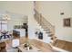 Open-concept living space with hardwood floors, a modern staircase, and a view of the updated kitchen at 21472 E 46Th Ave, Denver, CO 80249