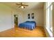 Sunny bedroom featuring wood floors, ceiling fan, and a beautiful view of outside through a large window at 10132 Nickolas Ave, Highlands Ranch, CO 80130