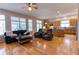 Bright living room with hardwood floors, large windows, and comfortable seating near an open kitchen and ceiling fan at 10132 Nickolas Ave, Highlands Ranch, CO 80130