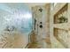Modern tiled shower featuring a rainfall showerhead, shower bench and decorative tiling. Storage shelves! at 10132 Nickolas Ave, Highlands Ranch, CO 80130