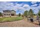 Spacious backyard featuring a well-maintained lawn, stone patio, and inviting fire pit area, perfect for relaxation at 282 N De Gaulle St, Aurora, CO 80018