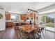 Bright dining area with wood floors, modern lighting, a large wood table, and sliding doors opening to the outdoors at 282 N De Gaulle St, Aurora, CO 80018