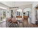 Elegant dining room featuring wood floors, modern lighting, a large table, and seamless flow to the living area at 282 N De Gaulle St, Aurora, CO 80018