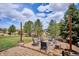 Beautiful fire pit area with Adirondack chairs, string lights, and a rustic wooden border, perfect for outdoor entertaining at 282 N De Gaulle St, Aurora, CO 80018