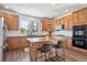 Well-lit kitchen with wood cabinets, center island, stainless appliances, granite countertops, and hardwood floors at 282 N De Gaulle St, Aurora, CO 80018