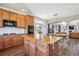 Modern kitchen with wooden cabinets, center island, hardwood floors, stainless appliances, and access to living and dining spaces at 282 N De Gaulle St, Aurora, CO 80018