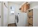 Well-organized laundry room with modern washer and dryer, storage cabinets and shelving at 282 N De Gaulle St, Aurora, CO 80018