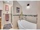 Bright bathroom features a stand alone tub, stylish fixtures, decorative wall art, and a glass shower door at 3817 Ponderosa Dr, Evergreen, CO 80439