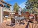 Exterior deck offers a seating arrangement with a glass table and umbrella, surrounded by pine trees at 3817 Ponderosa Dr, Evergreen, CO 80439