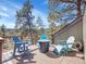 Back deck featuring rocking chairs, Adirondack chairs, a fire pit, and sweeping views of the treeline at 3817 Ponderosa Dr, Evergreen, CO 80439