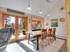 Bright dining room with hardwood floors, vaulted ceiling, and access to an outdoor deck at 3817 Ponderosa Dr, Evergreen, CO 80439