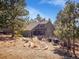 Charming home exterior highlighting the home's lush landscaping and mountain setting at 3817 Ponderosa Dr, Evergreen, CO 80439