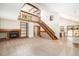 Open-concept living area featuring vaulted ceilings, a fireplace, a staircase, and seamless flow to the kitchen at 136 S Eagle Cir, Aurora, CO 80012