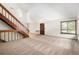 Open living room featuring staircase and hardwood floors leading to the front door and large windows at 136 S Eagle Cir, Aurora, CO 80012