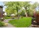 Spacious backyard with a well-manicured lawn, mature trees, and a dining area under a white umbrella at 10000 E Ohio Ave, Denver, CO 80247