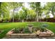 Beautiful backyard garden featuring a stone fountain, lush greenery, and a wooden privacy fence at 10000 E Ohio Ave, Denver, CO 80247